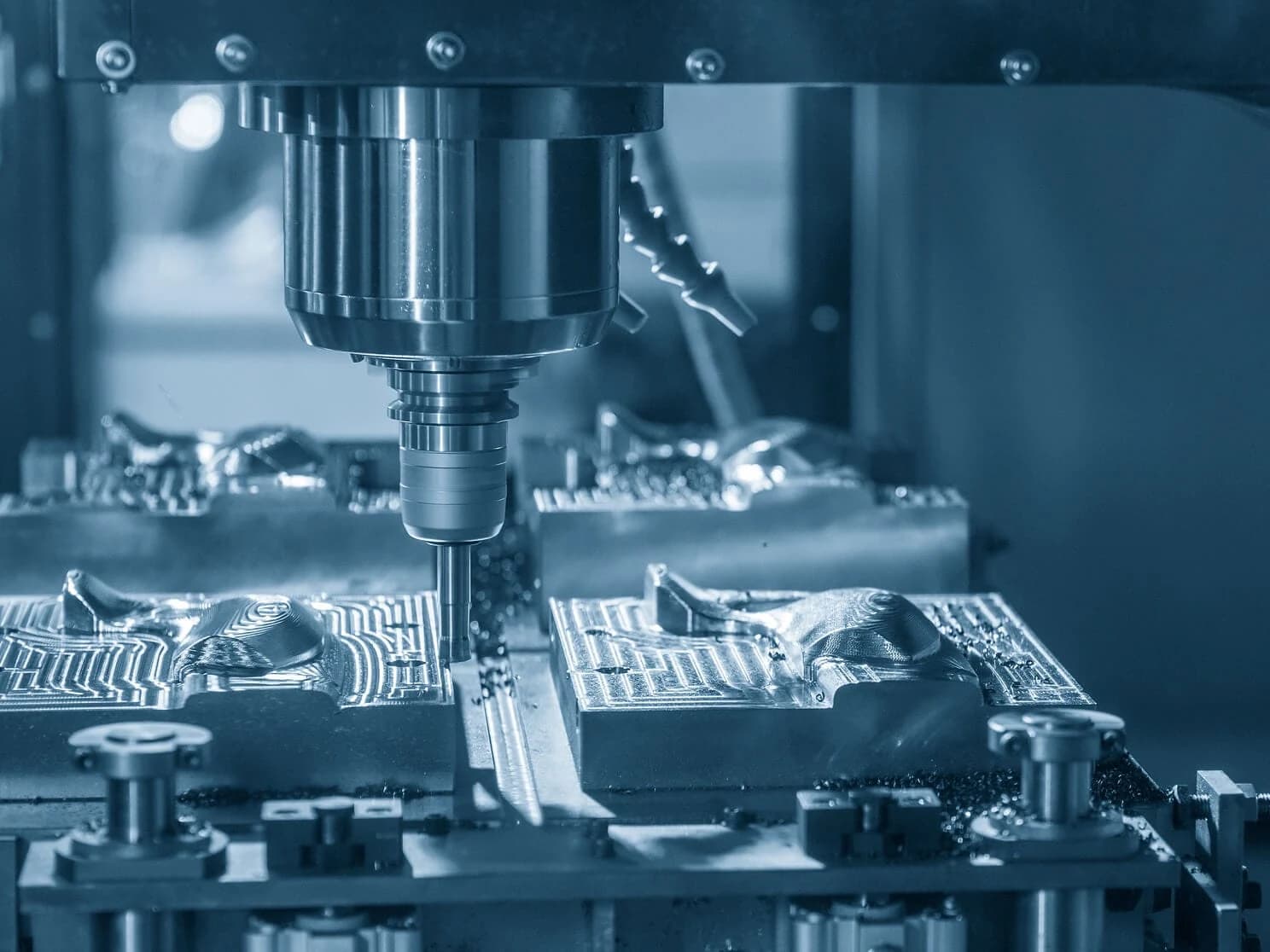 Herramienta trabajando cavidades y relieves sobre bloques metálicos
